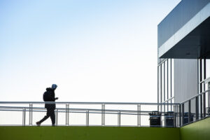 A student walking across the sky bridge to the ARC