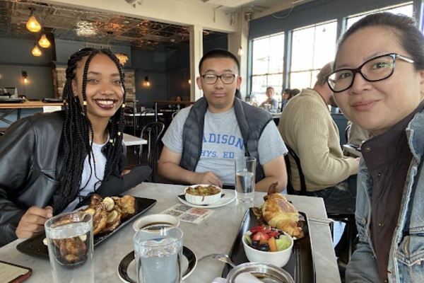 two students meets with intern site-supervisor over lunch.