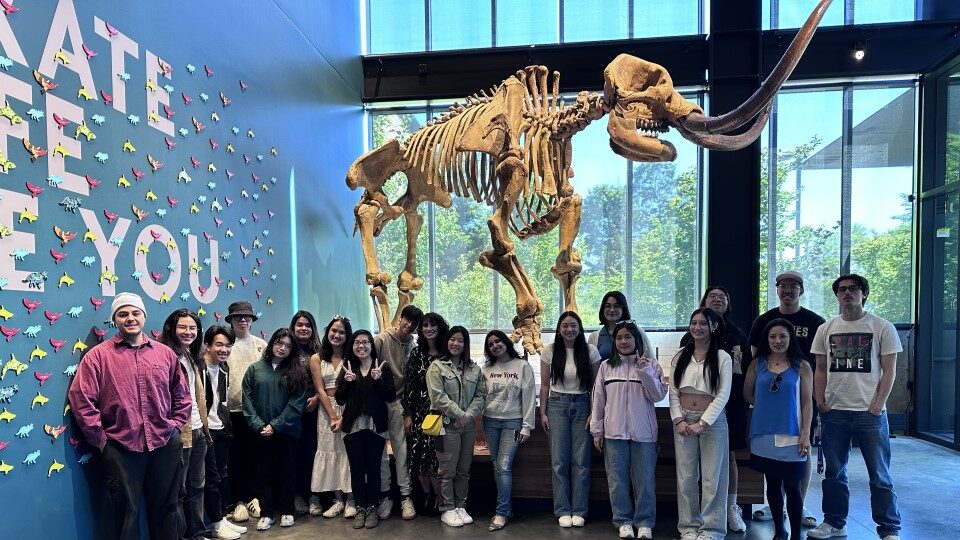 2024 SEAPF Cohort at the Burke Museum standing next to dinosaur skeleton