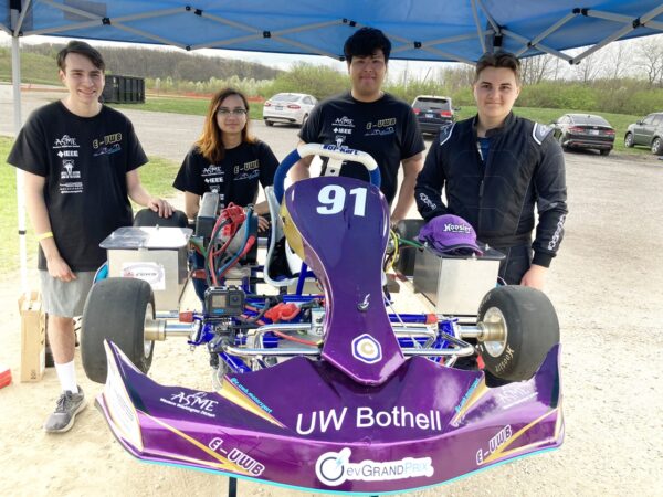 A group of people standing around a racecar.