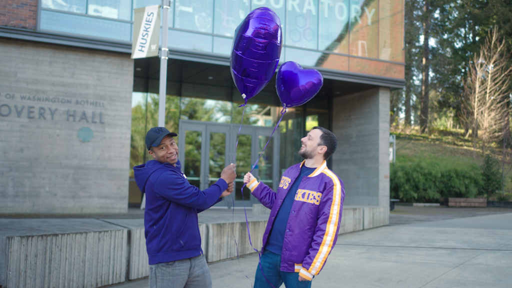 Two people holding balloons.