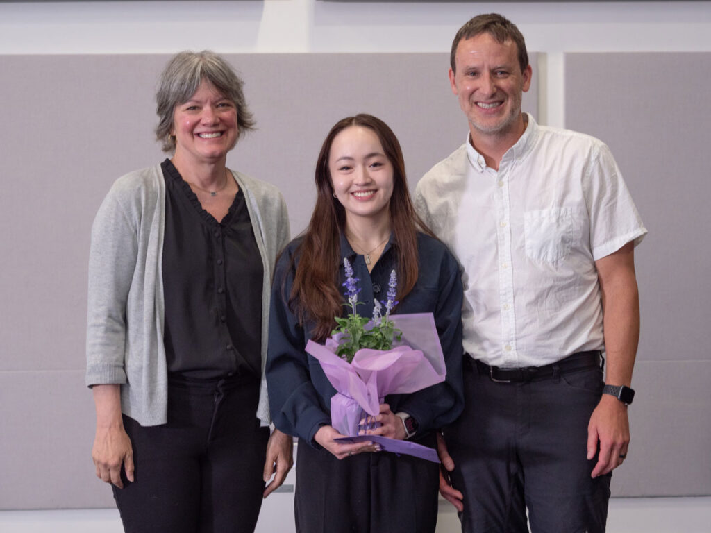 Three people pose for a photo.