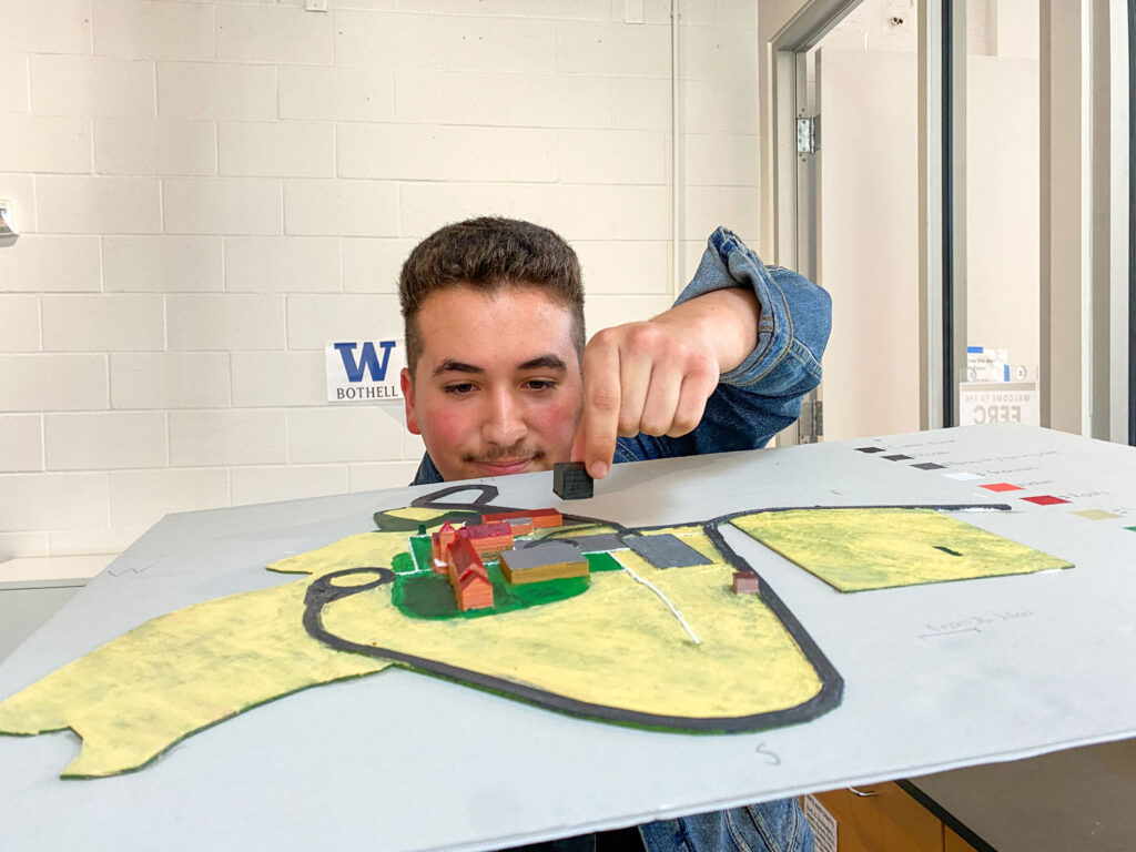 A person holding up a cube on a 3D map.