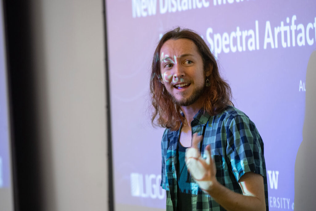 A person talking in front of a projector screen.