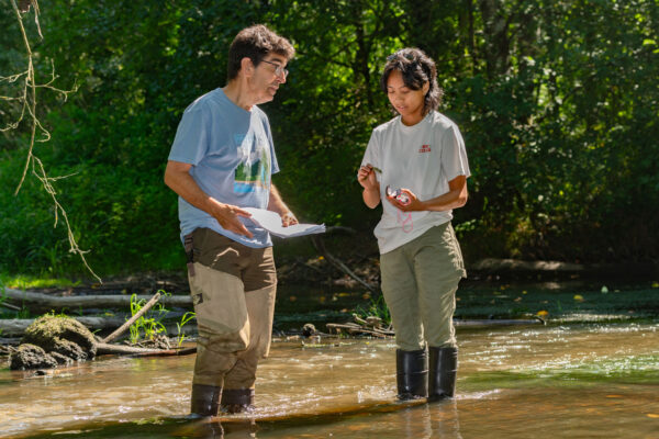 Two people in waders in a creek.