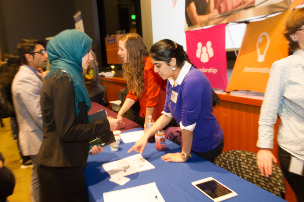 Two women viewing a document from opposite sides of a table. 