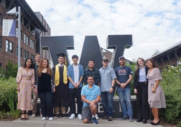 Group of students standing in front of the "W" sculpture.