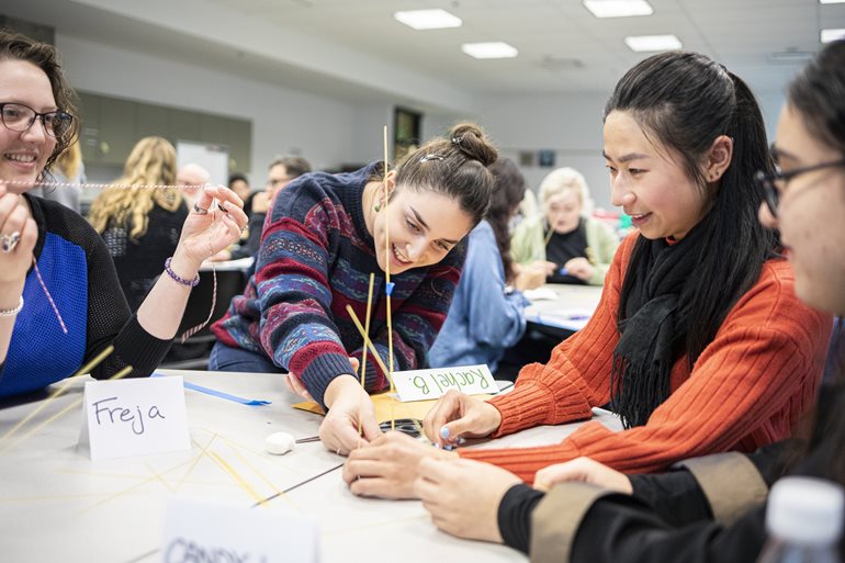 Students build with sticks of spaghetti.