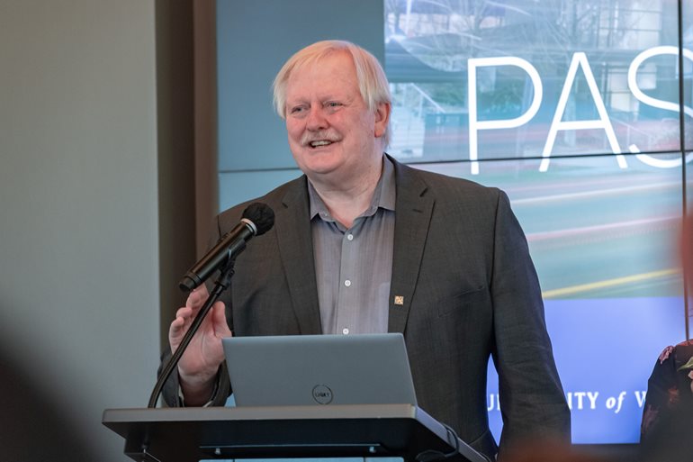 William Erdly standing at the podium during the colloquium