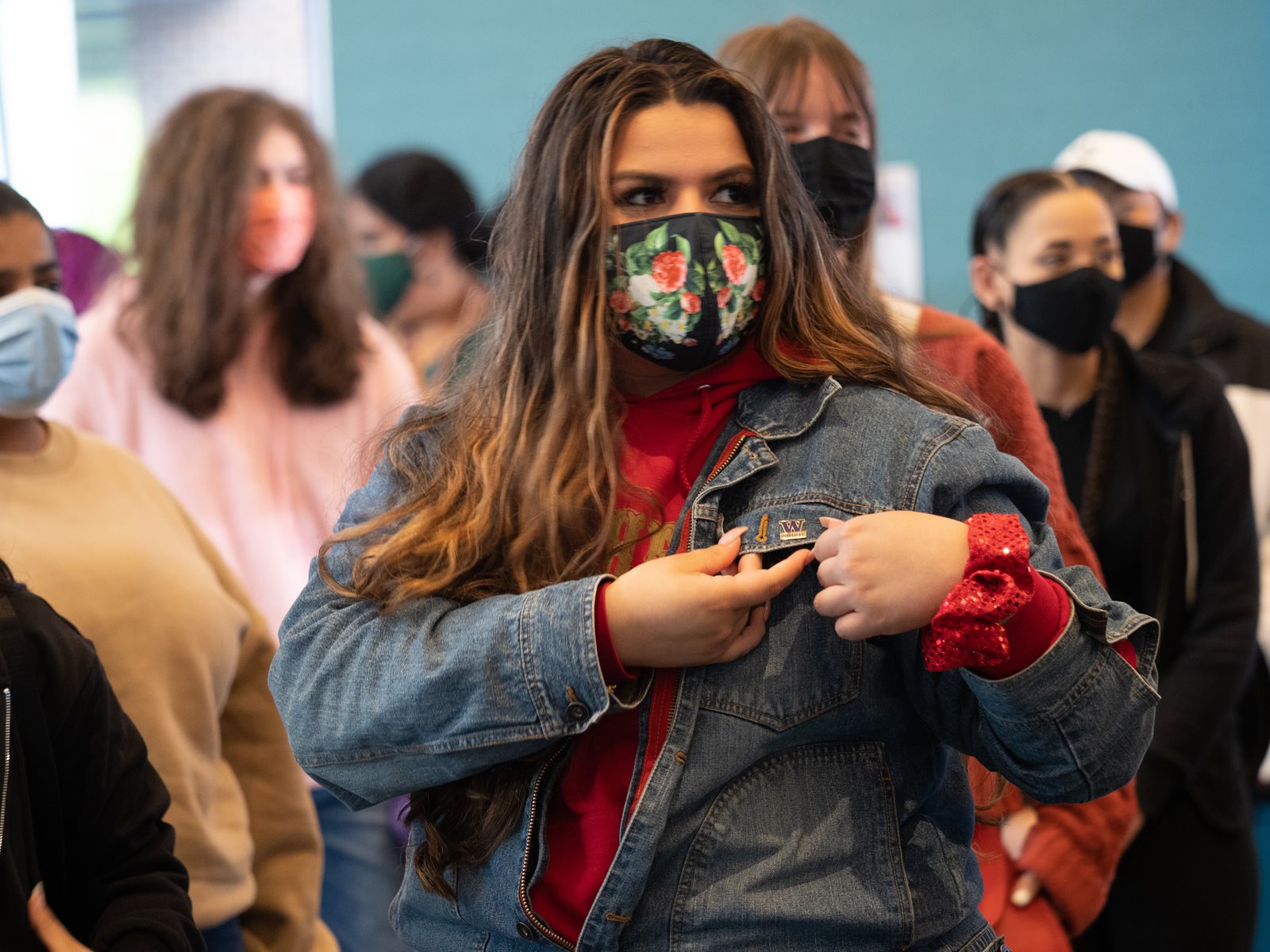 A female student putting a pin on jacket