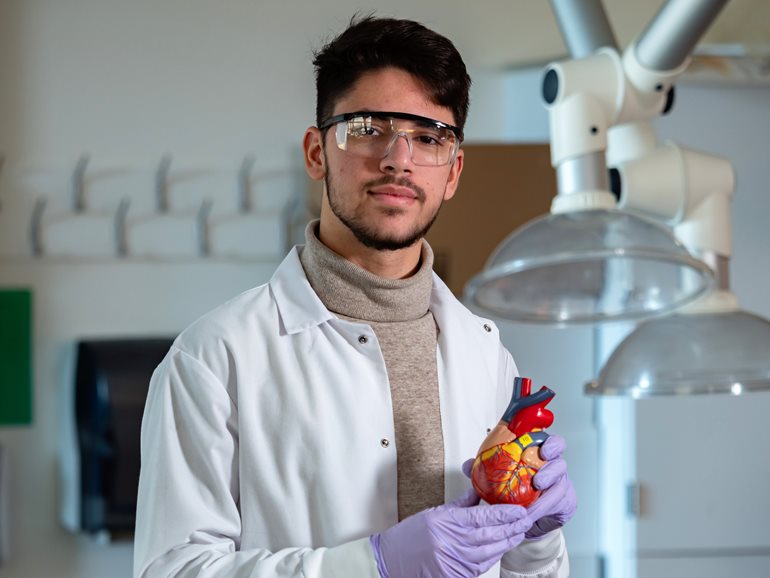 Djelli Barisha holds a heart model in a UW Bothell lab.