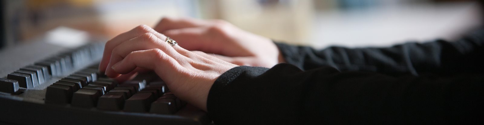 Hands on a keyboard typing, searching online