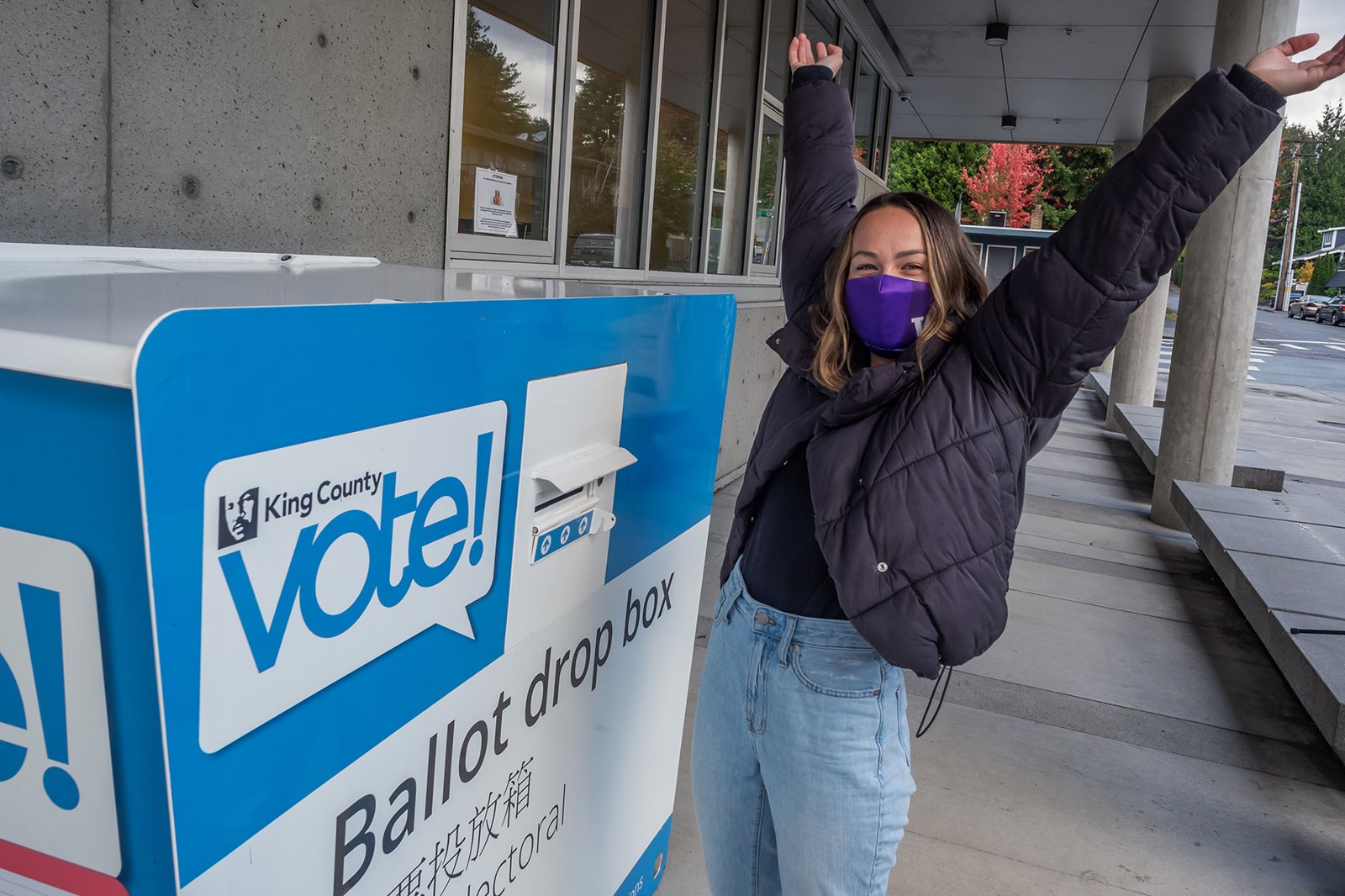 Elisabeth celebrating her vote by the ballot drop box