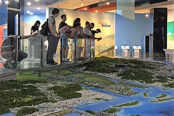 Students look at model of Busan.