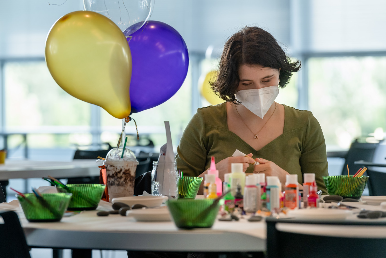 attendee painting a rock amid decorations