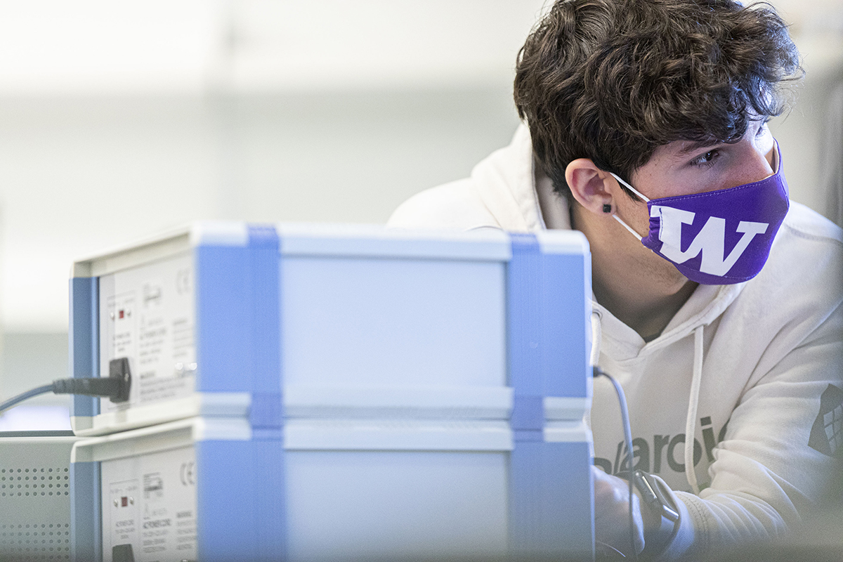 Physics student in the classroom, wearing a mask