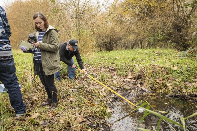 Students collect water samples in the wetlands